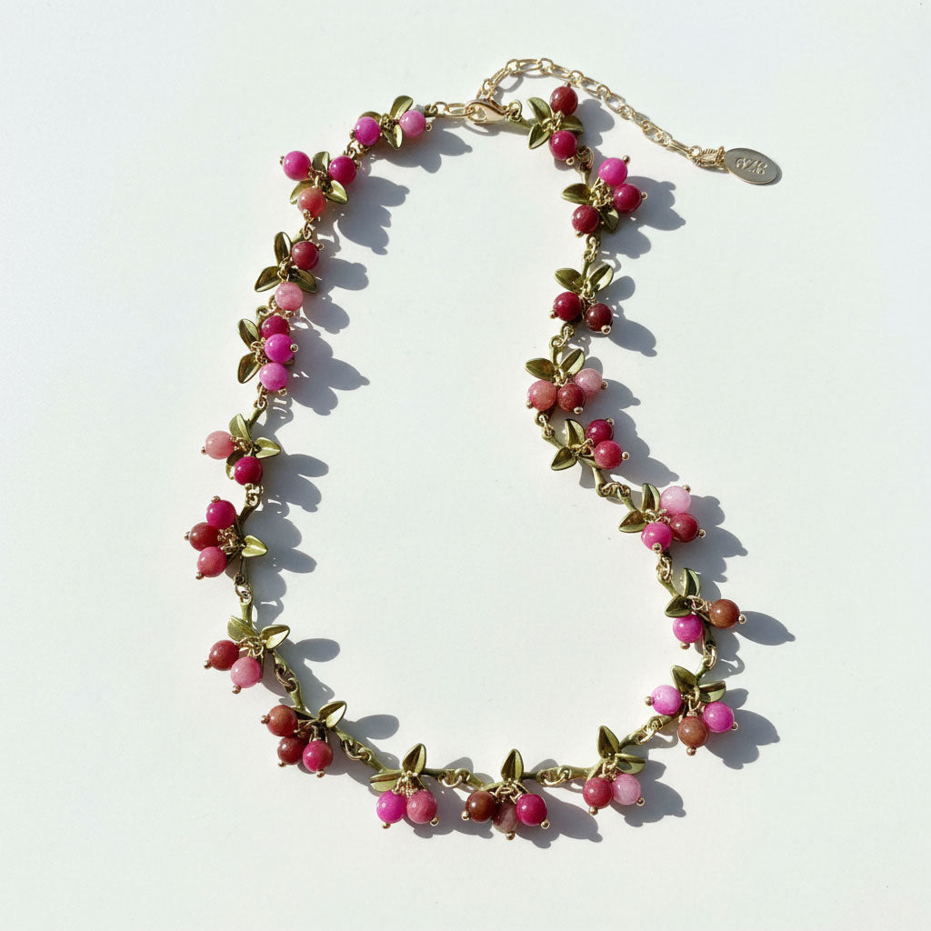 Necklace with pink and red beads on a white background