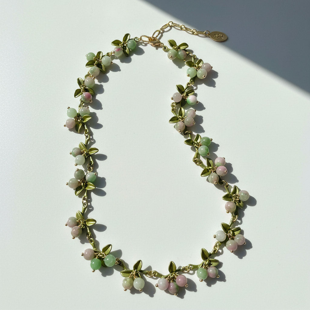 Necklace with green and pink beads on a white background