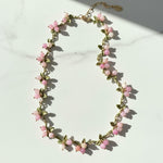 Necklace with pink floral beads on a light background