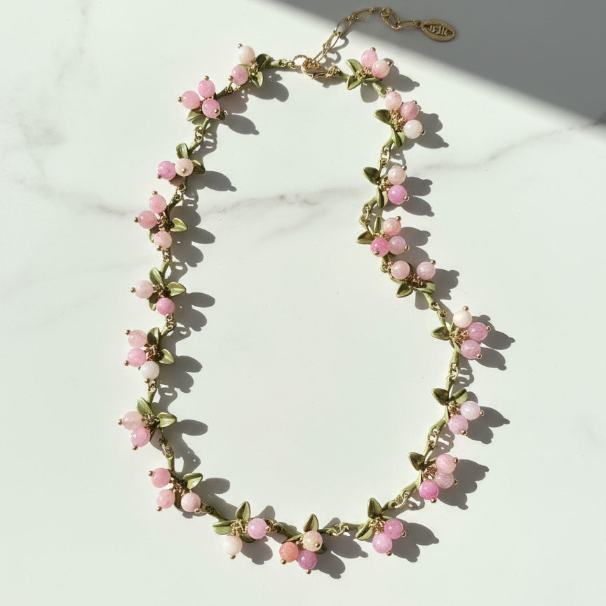 Necklace with pink floral beads on a light background