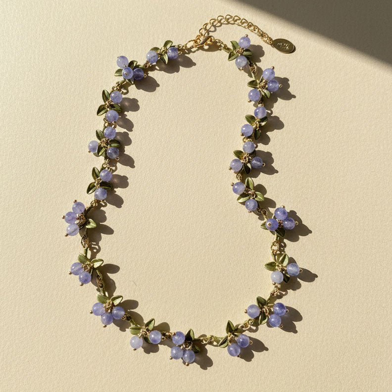 Necklace with purple floral beads on a beige background