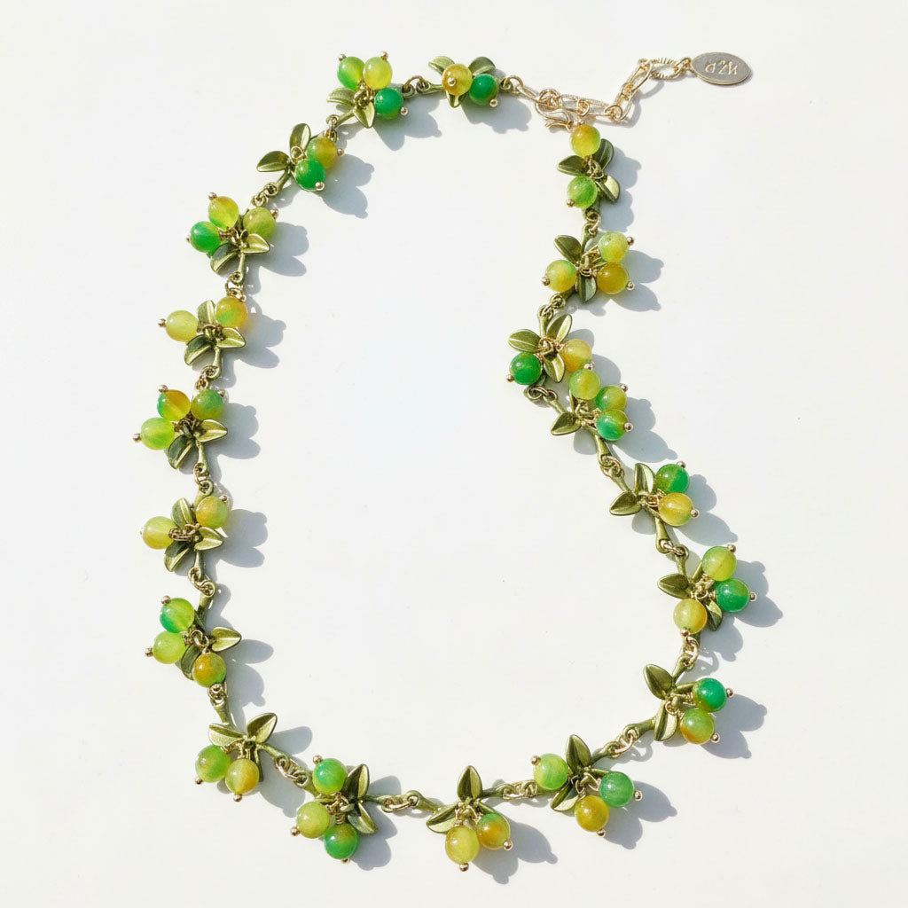 Necklace with green beads and gold chain on a white background
