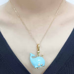 Necklace with a blue whale pendant on a mannequin wearing a navy sweater.