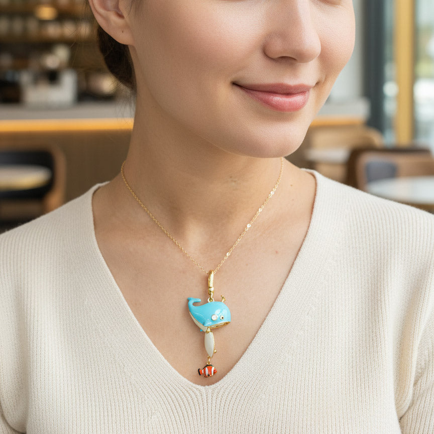 Woman wearing a necklace with a blue whale pendant in a casual setting