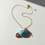 Necklace with a blue pendant on a light gray background