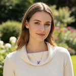 Woman wearing a beige sweater with a blurred garden background