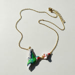 Necklace with a colorful parrot pendant on a light gray background