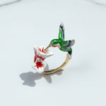 Enamel hummingbird and flower ring on a white background