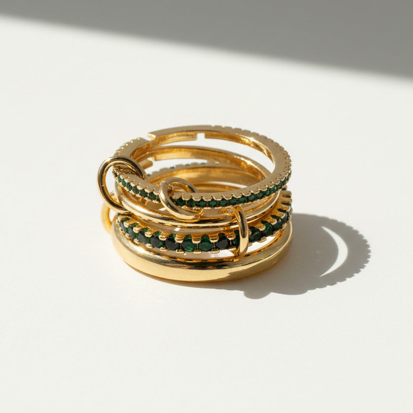 Stack of gold and green rings on a light background