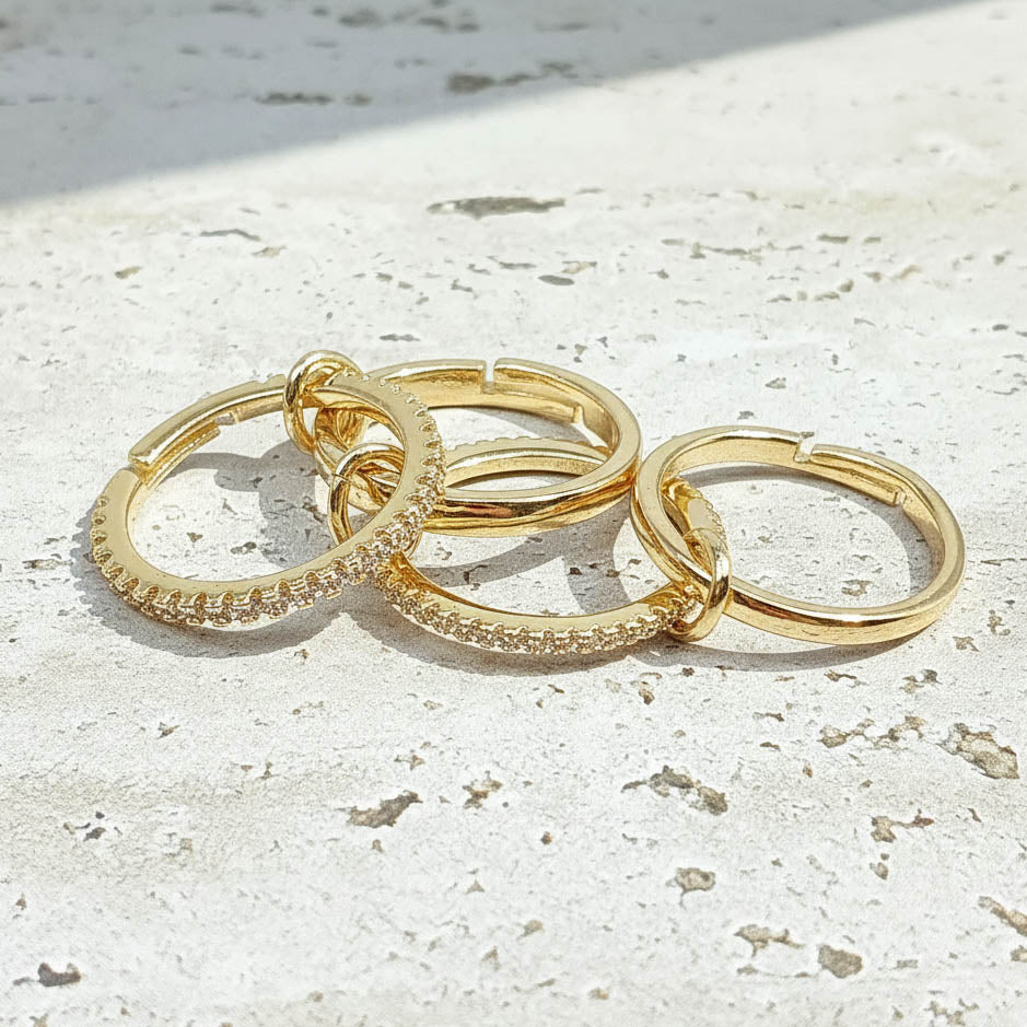 stackable gold hoop rings on a light stone surface