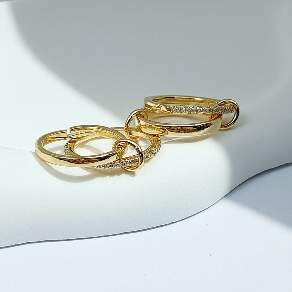 Gold rings with embedded stones on a light background