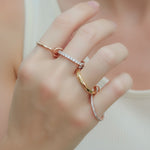 Gold ring with diamond accents on a hand against a blurred background