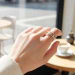 Hand wearing a ring with a blurred cafe background