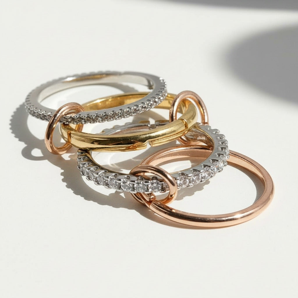 Three-tone linked ring set in gold, silver, and rose gold with clear cubic zirconia stones on light background.