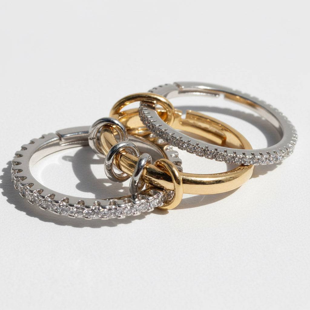 Three gold and silver rings stacked on a light gray background