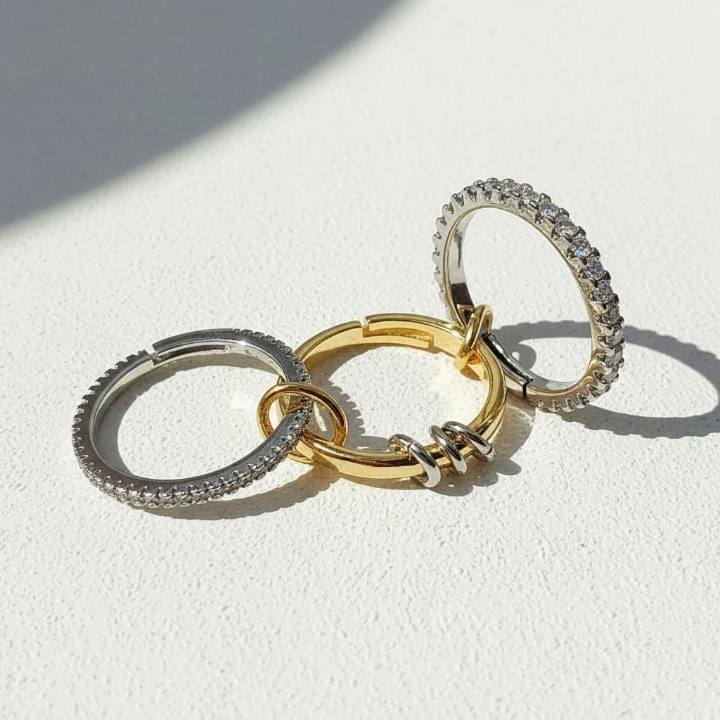 Three rings in gold, silver, and rose gold on a light background