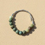 African Turquoise Jasper gemstone bracelet on sand surface with stainless steel hook detail