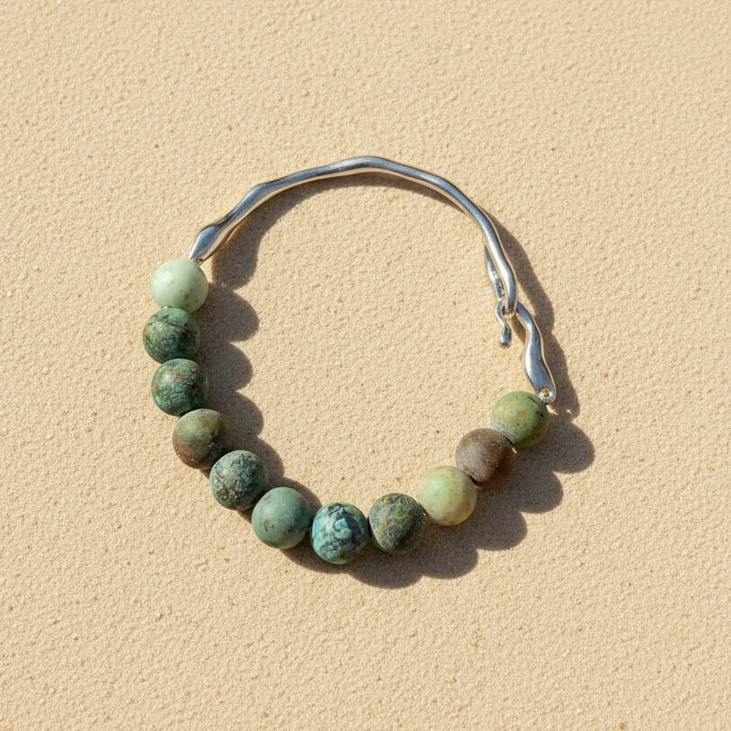 African Turquoise Jasper gemstone bracelet on sand surface with stainless steel hook detail
