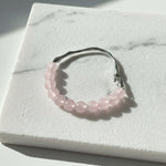 Rose Quartz beaded bracelet with stainless steel hook on white marble background