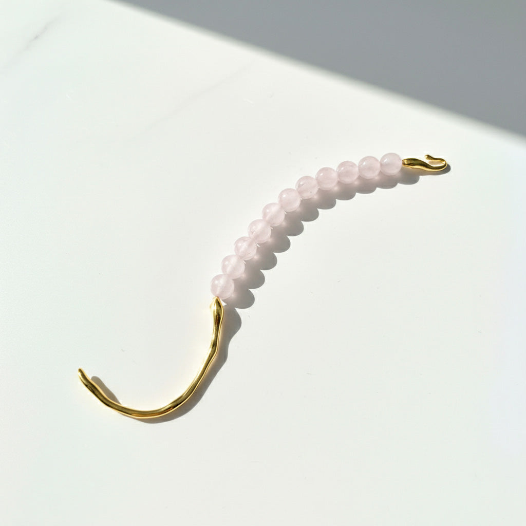 Rose Quartz bracelet with 18K gold PVD stainless steel hook detail in soft sunlight