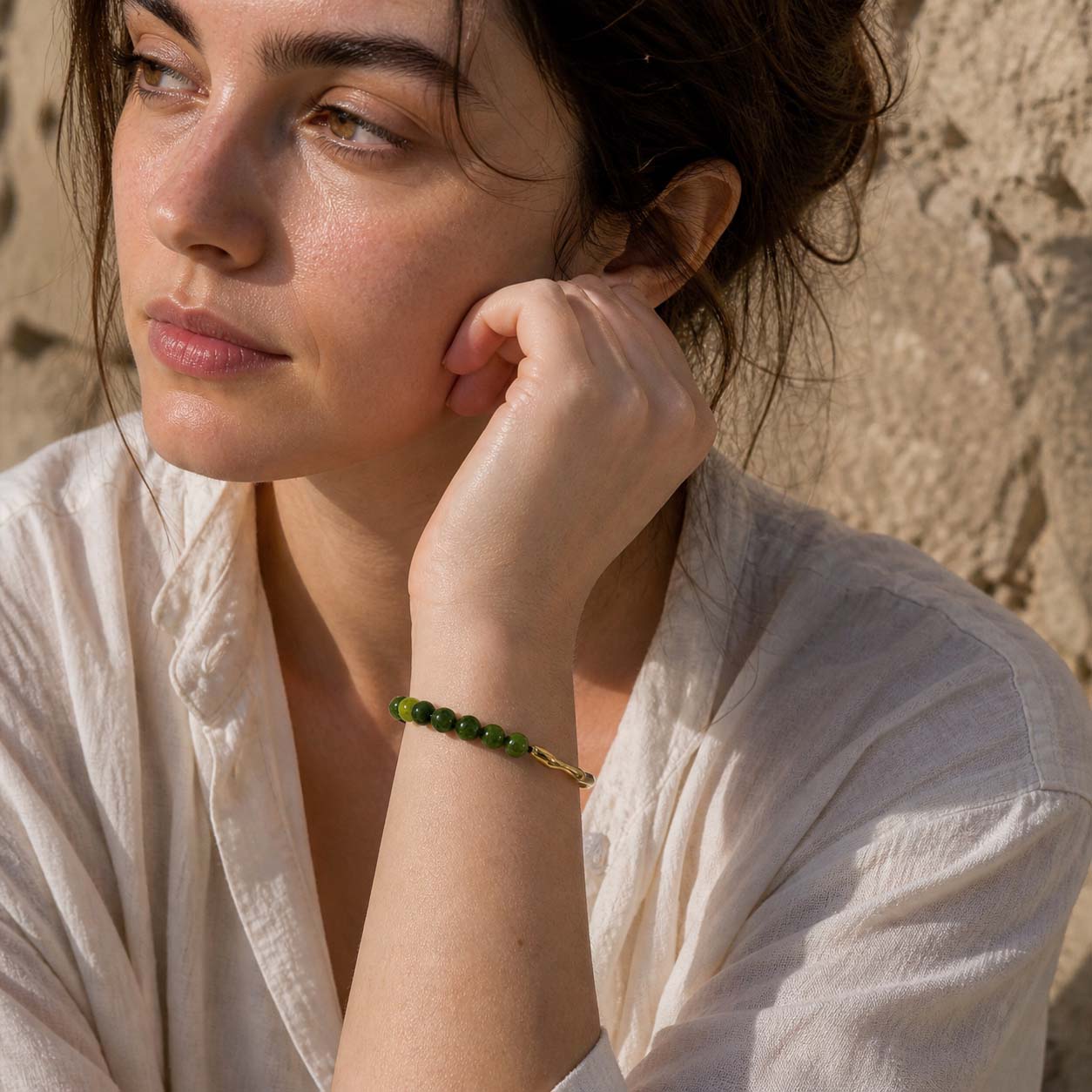 Woman wearing green chalcedony beaded bracelet with gold hook detail