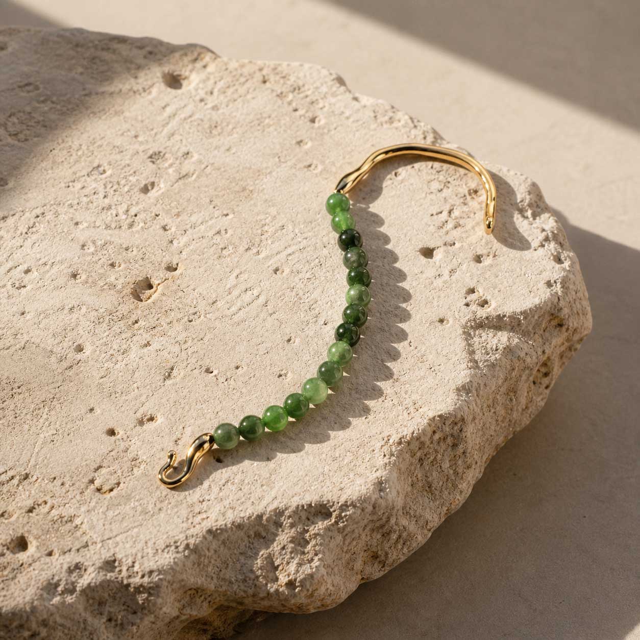 Green chalcedony bracelet styled on natural beige stone slab