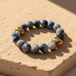 10mm Blue Aventurine bracelet with gold PVD stainless beads on natural stone display