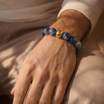 Close-up of a male hand wearing a bracelet blue Aventurine gemstone beads with polished gold stainless steel bead detail