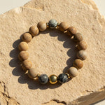 10mm matte Picture Jasper bracelet with Zebra Jasper and gold stainless steel bead on a stone surface