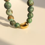 Close-up of matte African Turquoise beads with polished gold stainless steel bead