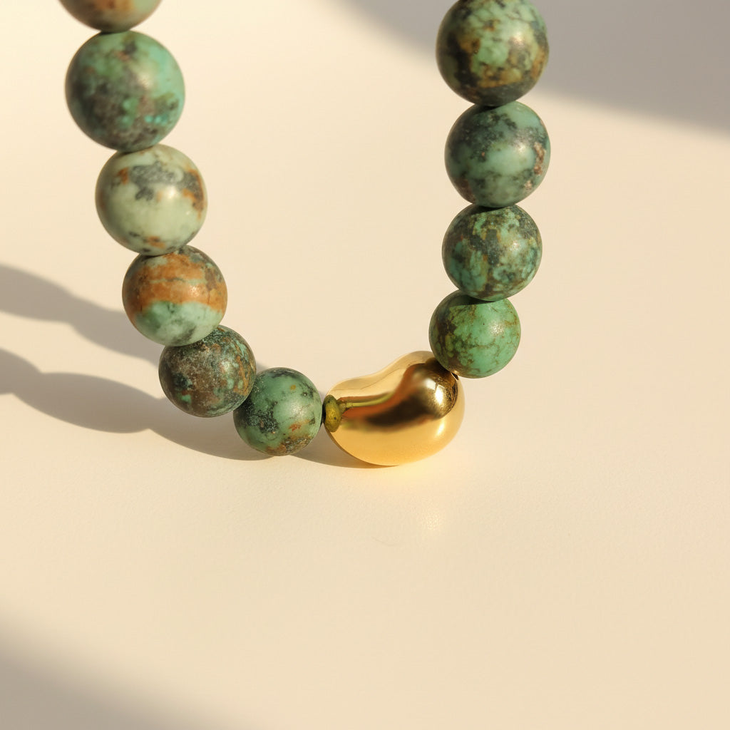 Close-up of matte African Turquoise beads with polished gold stainless steel bead