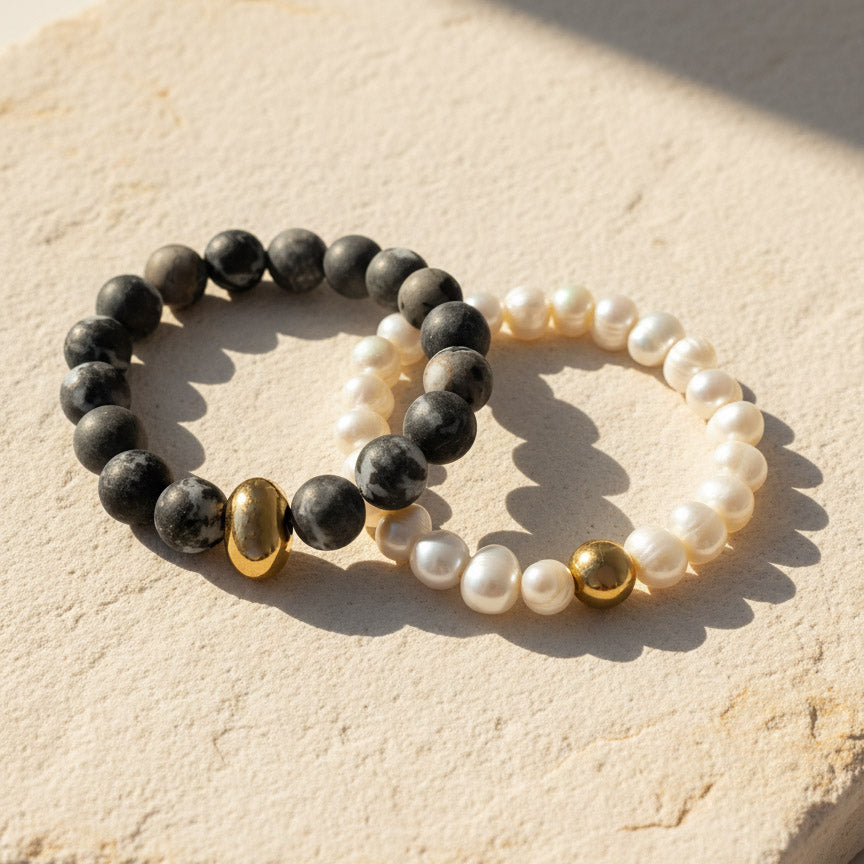Picasso Jasper and freshwater pearl bracelet with gold stainless steel bead on a beige surface.