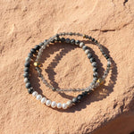 Zebra jasper and pearl bracelet with black rutilated quartz beads on natural stone surface
