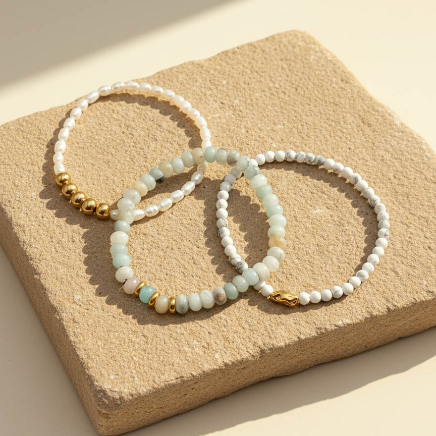 Amazonite and white turquoise gemstone bracelet set with pearl on natural stone background