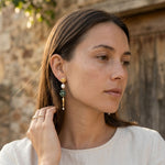 Woman wearing ruby zoisite gemstone drop earrings with pearl accents