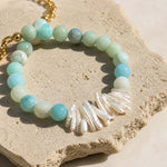 Close-up of baroque pearls and matte amazonite beads on stone surface