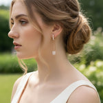 Woman wearing elegant earrings with a blurred green background